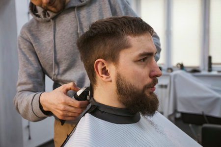 A hairdresser or barber is working with a shaving machine on the hair.の写真素材