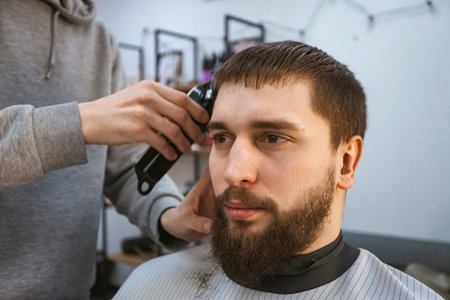 A hairdresser or barber is working with a shaving machine on the hair.の写真素材