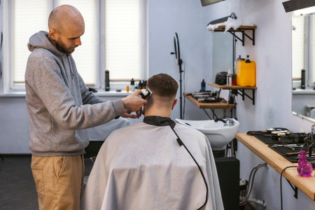 A hairdresser or barber is working with a shaving machine on the hair.の写真素材