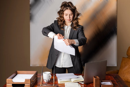A beautiful businesswoman, formally dressed, tears up papers. unsuccessful business. breaking contract document.の写真素材