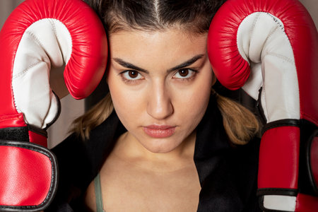 Portrait of a girl wearing red boxing gloves, standing in a blocking stance.の写真素材