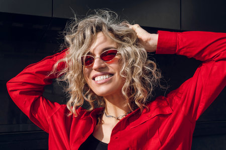Street photography. A happy stylish girl in red slim glasses and unbuttoned shirt.の写真素材