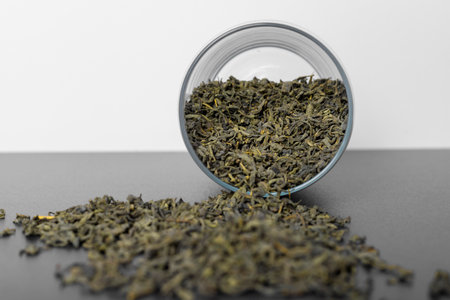 Glass jar are lying on their side with loose leaf tea spilled out.の写真素材