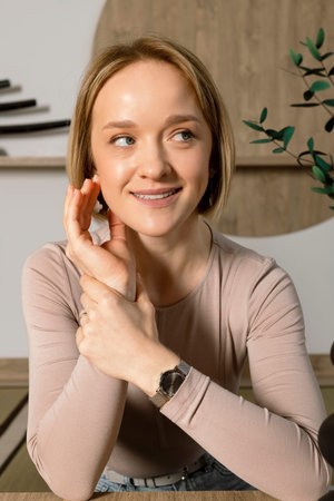 Portrait of a Cute young blonde woman in a beige top, happy smiling, Japanese style studio at the...