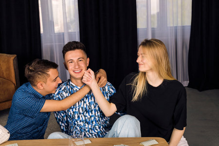 A favorite guy among friends getting attention. three friends, small group of people. a man that everyone likes.の写真素材