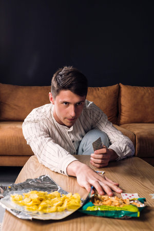 Confident man plays card game with friends and makes his move.