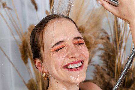 Charming young girl sitting in a bath, taking shower. Beauty and skin care concept.の写真素材