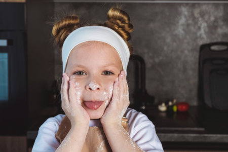 Little girl having fun in the kitchen. The concept of family values.の写真素材