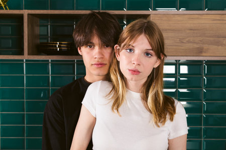Young teenage couple on the kitchen hugging after a quarrel, forgiving each other. beautiful two...