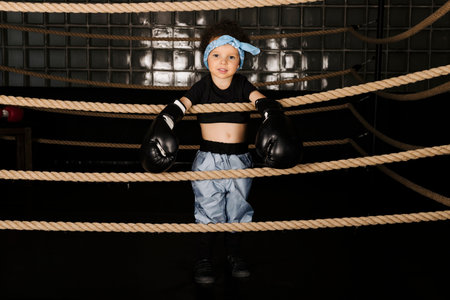 Cute little girl playing in the boxing ring, wearing boxing glovesの写真素材
