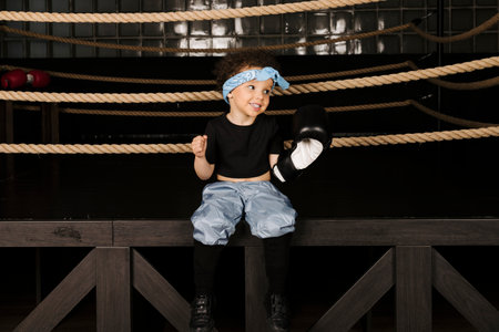 Cute little girl playing in the boxing ring, wearing boxing glovesの写真素材