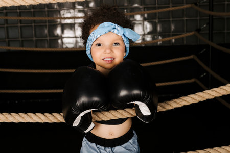 Cute little girl playing in the boxing ring, wearing boxing glovesの写真素材