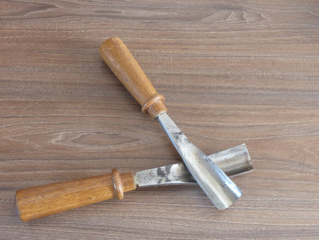 two wood carving chisels on a wooden backgroundの写真素材