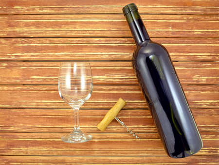 Image of a bottle of red wine and glass on background wooden slatsの写真素材