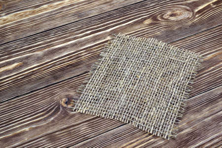 Piece of burlap cloth that is on the table of wood boardsの写真素材