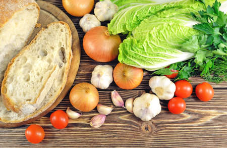 Bread with vegetables and greens for lunch on a wooden tableの写真素材