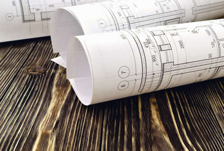 Photo drawings for the project engineering work that lie on background a wooden tableの写真素材
