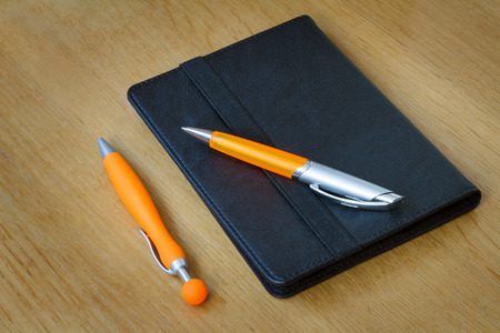 
Two handles of bright orange color for the letter and multi-colored paper clips for documents. Are located on a tableの写真素材
