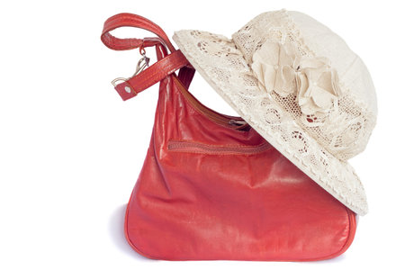 Female hat from a linen cloth and lacy fabric for protection against the sun and a leather bag. Are presented on a white background.の写真素材