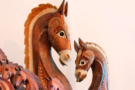 Woodcarving: original figures of horses on a light pink background.の写真素材