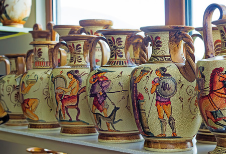 On the shelf in the store are beautiful ceramic vases with painted antique subjects.の写真素材