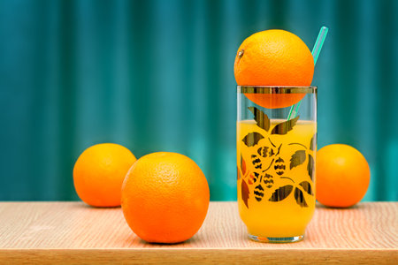 Fresh orange juice in the glass and some oranges on the table..の写真素材