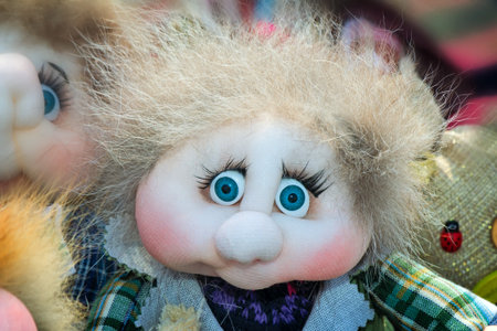 Funny doll of rags in the form of a little man with big blue eyes and luxuriant hair.