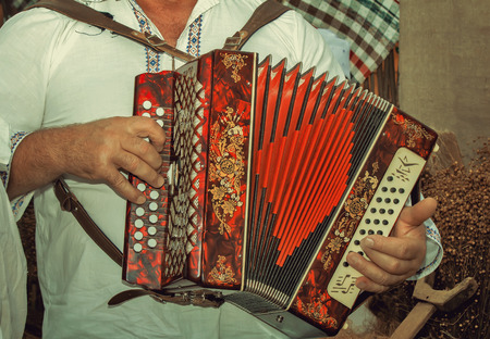 Man in national dress playing the accordion beautifully decorated during the festival.の写真素材