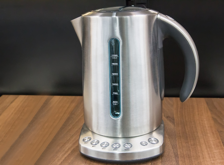 On the surface of the table there is an electric kettle with different temperature modes for heating water.の写真素材