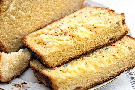On the plate is sliced mouth-watering sweet white bread. Presents closeup.