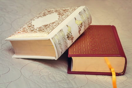Two beautiful books lie on the couch in the background of a beautiful bedspread.