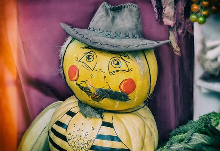The decoration for the harvest festival: a funny figure of a man in a hat made of pumpkin.の写真素材