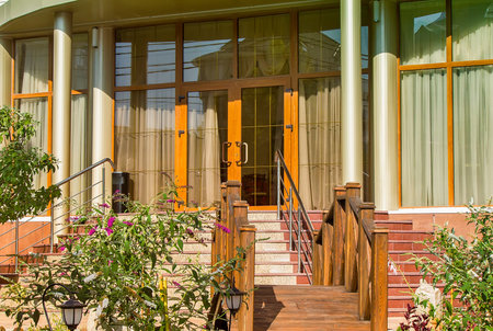 The hotel entrance is decorated with columns, decorative flowers and wooden staircase.の写真素材