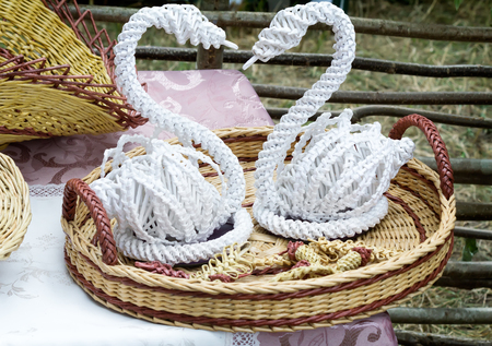 Crafts: two beautiful figures of swans, woven by hand from white stripes.の写真素材