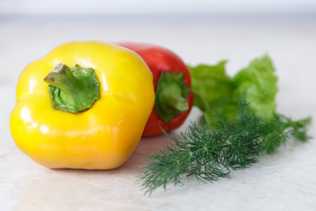 On the table lay a large ripe fruit of the pepper red, yellow and green.