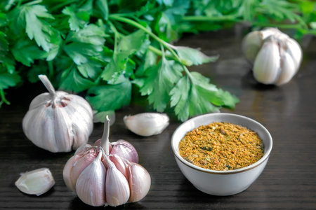 On the table lay the parsley leaves, spices and garlic. ( Photo in the style of "dark key").の写真素材
