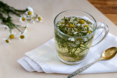 Medicinal chamomile is a valuable herbal medicinal raw material. Next in a Cup of herbal tea with chamomile infusion.の写真素材