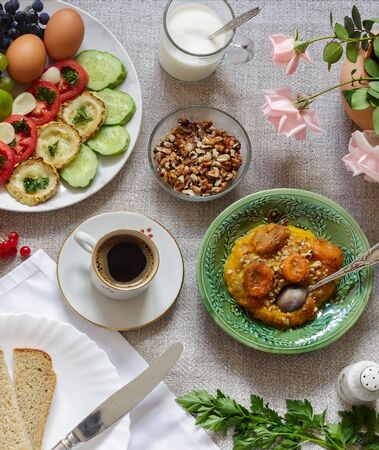 Healthy Breakfast: pumpkin puree with dried apricots, muesli, kefir, vegetables, eggs, coffee. Presented on a homespun rustic tablecloth, top view.の写真素材