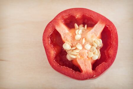 On a wooden background-a cross section of red bell pepper, top view. Healthy food concept, natural product.の写真素材