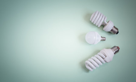 On a light background three small energy-saving lamps. The concept of energy saving. The view from...