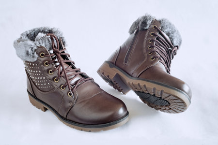 Comfortable and warm winter boots with gray fur inside, zipper and lace-up. Presented on a light background.の写真素材