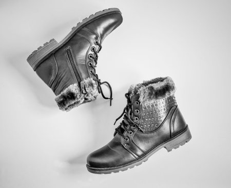 Comfortable and warm winter boots with gray fur inside, zipper and lacing. Presented on a light...