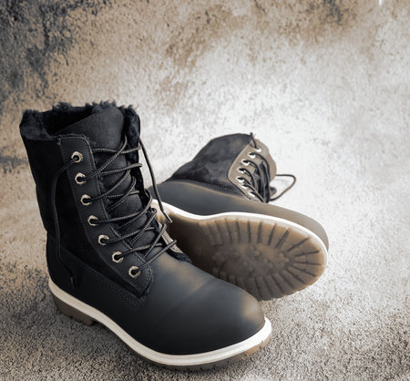 Comfortable and warm winter women's boots with faux fur inside and lacing. Presented on a light...