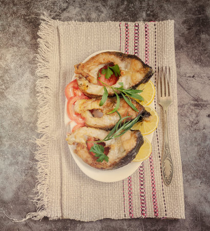 Fried fish carp on the table on a plate
