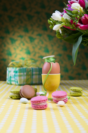 A decorated table with cookies, gift and easter egg in the egg holderの写真素材