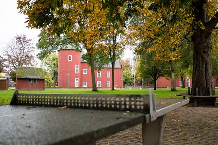 a lonely table tennis table in the city park under the rain with a red castle in the backgroundの写真素材