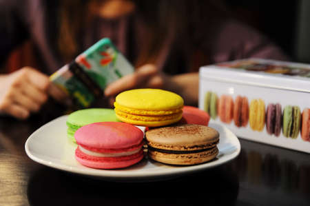 Girl shooting Colorful macaroons and gift box in cafeの写真素材