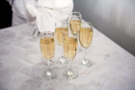 champagne glasses and man's hand on a table