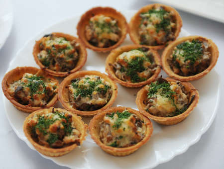 tartlets with chicken salad and herbs on white plateの写真素材