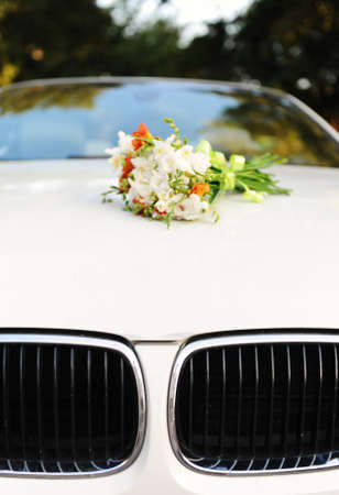 Bridal bouquet of flowers on the hood of white cabrioletの写真素材